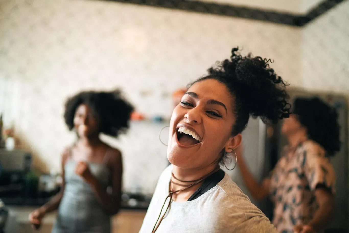 Friends dancing and having fun in kitchen.