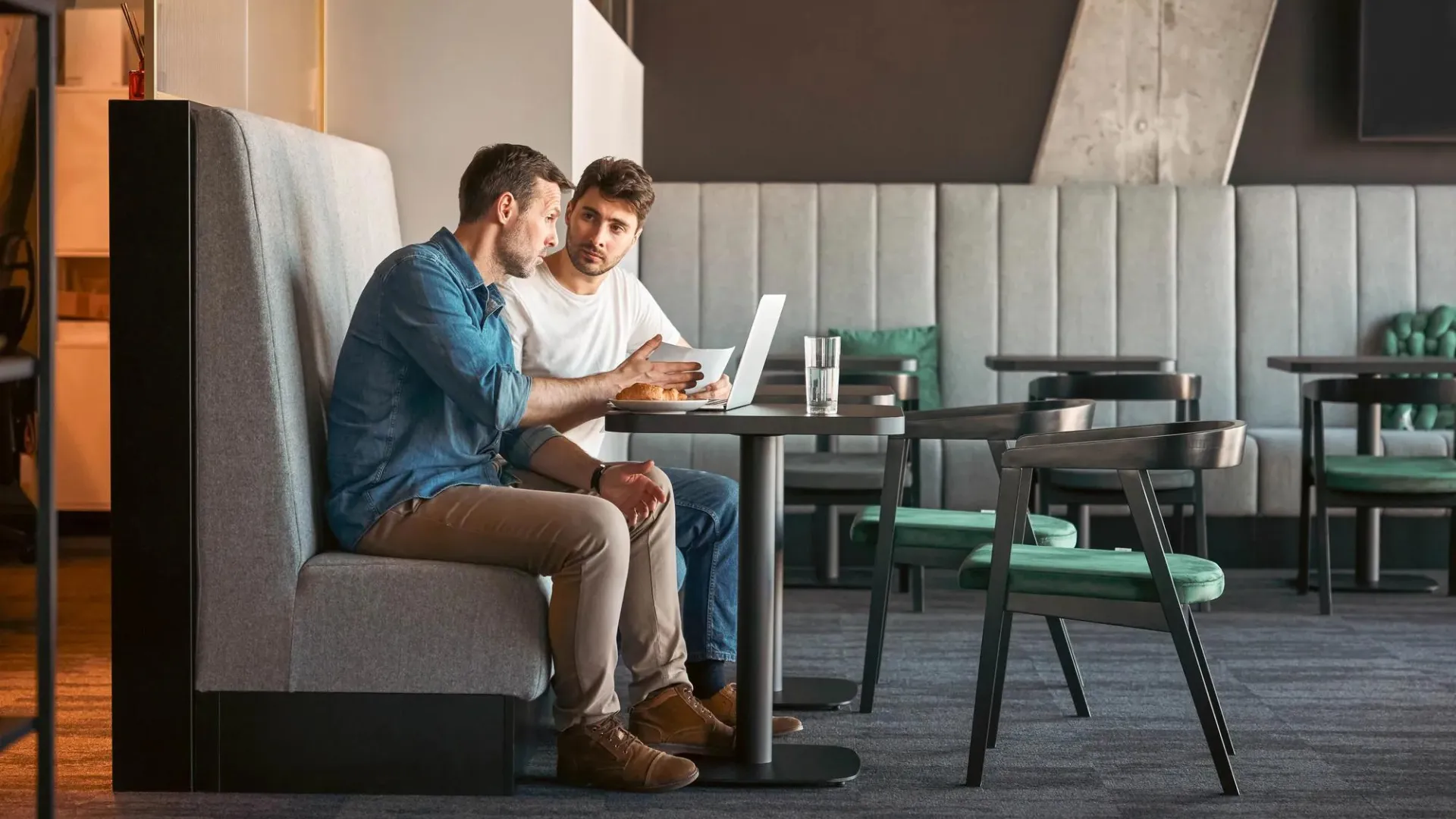 Two adult men looking at a computer